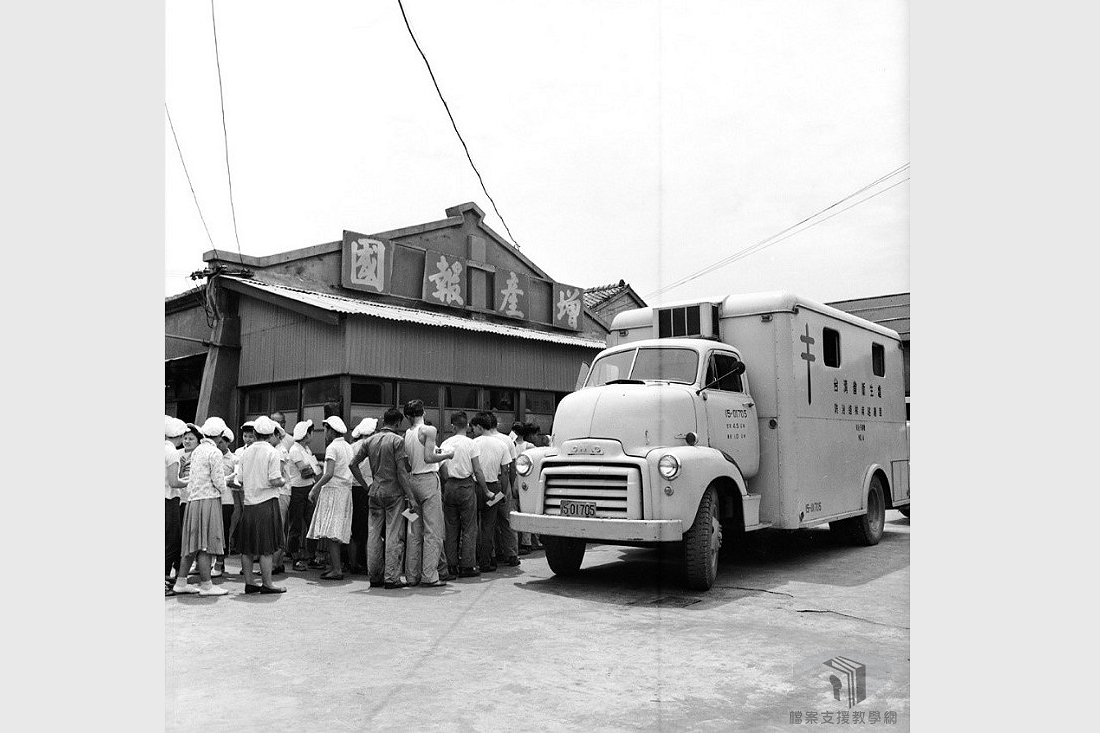民國49年(1960)，民眾得知衛生所派遣X光巡迴車為民服務，紛紛到場排隊，等待利用X光巡迴車上的儀器做肺結核健康檢查；一旁的房屋上掛有「增產報國」之標語，也反應出早年政府鼓勵民眾生育。檔案影像來源：國家發展委員會檔案管理局,檔案支援教學網(https://art.archives.gov.tw/FileImg.aspx?FileID=2868&ImgID=9714)